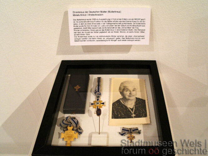 Ehrenkreuz der Deutschen Mutter (Mutterkreuz), Miniaturkreuz, Anstecknadeln | © Stadtmuseum Wels, Foto: Verbund Oö. Museen